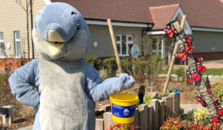 Alexander Devine Dolphin mascot with fundraising bucket.